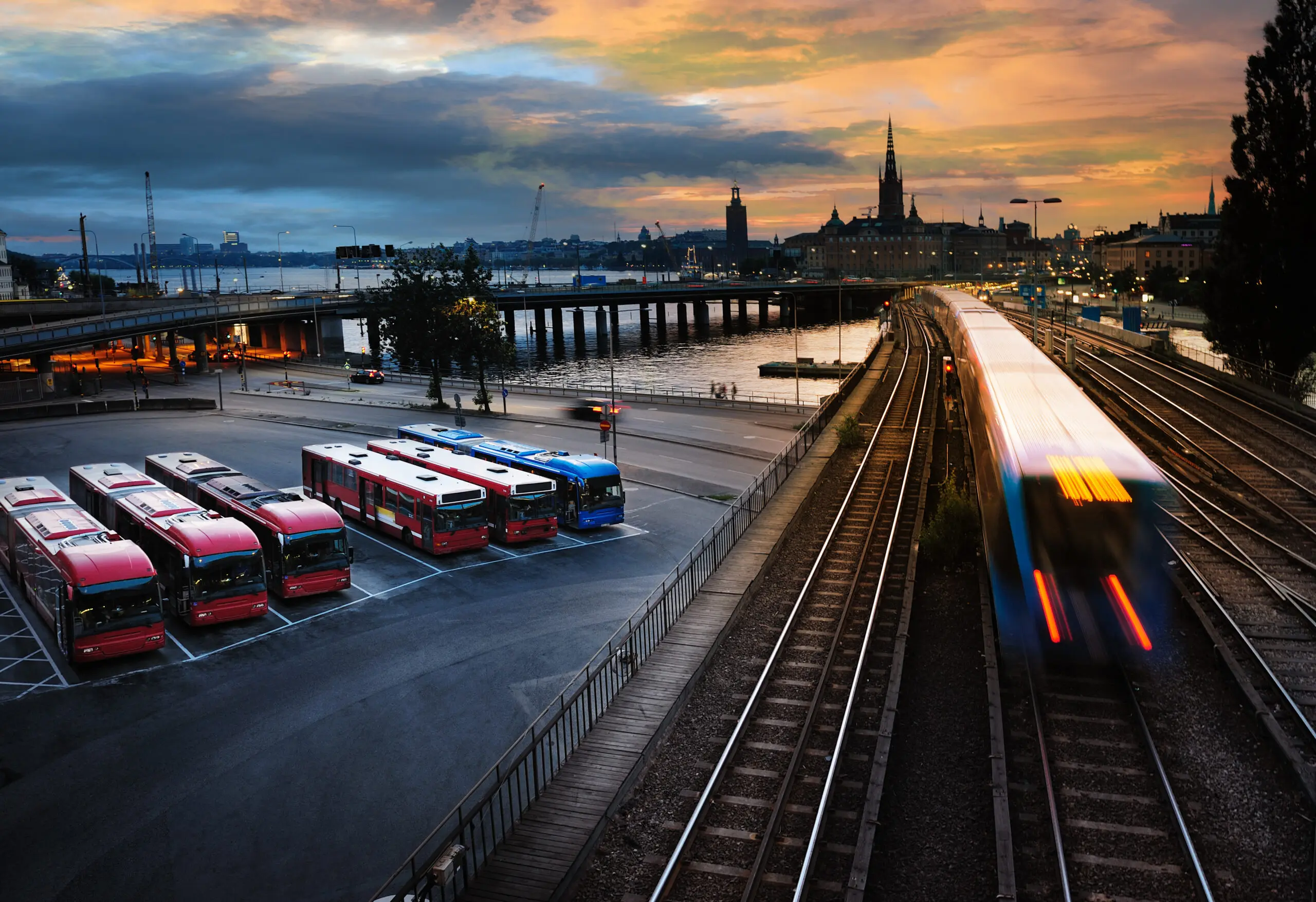 Parked buses and a speeding train in the city